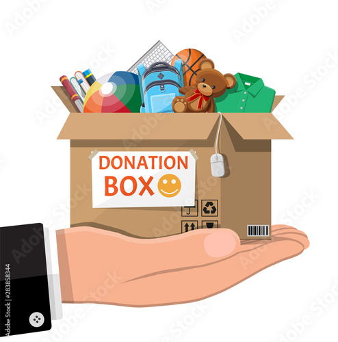 Cardboard donation box full of toys, books, clothes and devices. Help for children, support for poor kid. Donate container in hand. Social care, volunteering, charity concept. Flat vector illustration