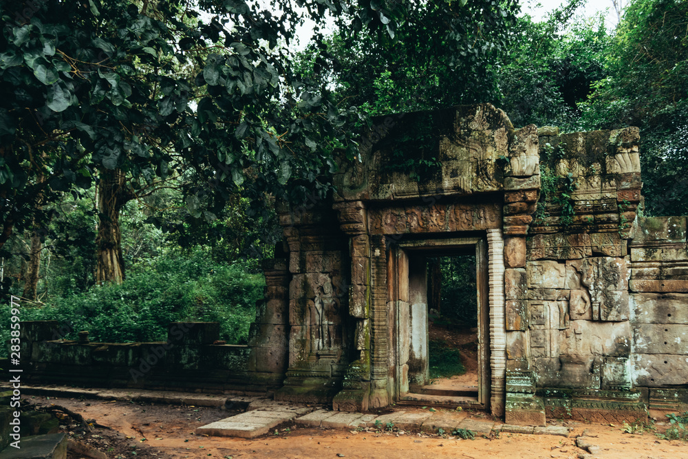 A gateway to one of the Bayon temples in Angkor, Siem Reap, Cambodia surrounded by a lush green forest - UNESCO World Heritage Site 1992