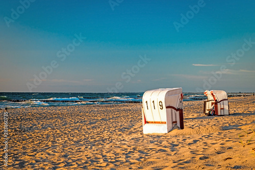 Fototapeta Naklejka Na Ścianę i Meble -  Beach chairs stand in the sunset on a beach on the Baltic Sea with sea
