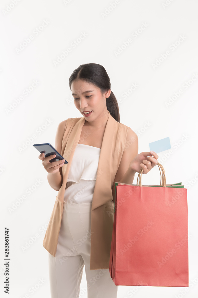 Portrait of asian woman holding credit card and smart phone for shopping online payment and colourful shopping bags, Online shopping concept. Free from copy space. Portrait of asian woman holding credit card and smart phone for shopping online payment and colourful shopping bags, Online shopping concept. Free from copy space.