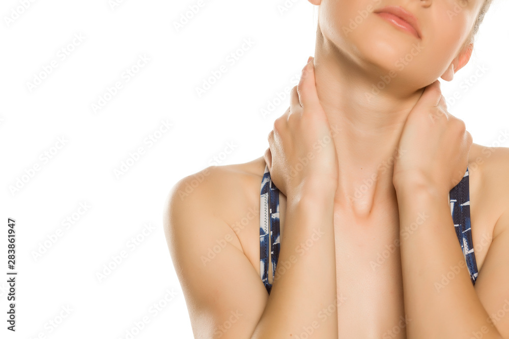 Young woman is holding her painful neck with her hands and resting. Isolated on white background. Closeup