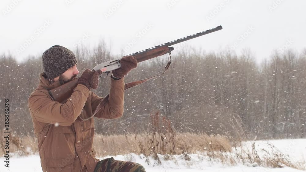 Young hunter pointed his weapon at the bird. Bird hunting concept Young hunter pointed his weapon at the bird. Bird hunting concept