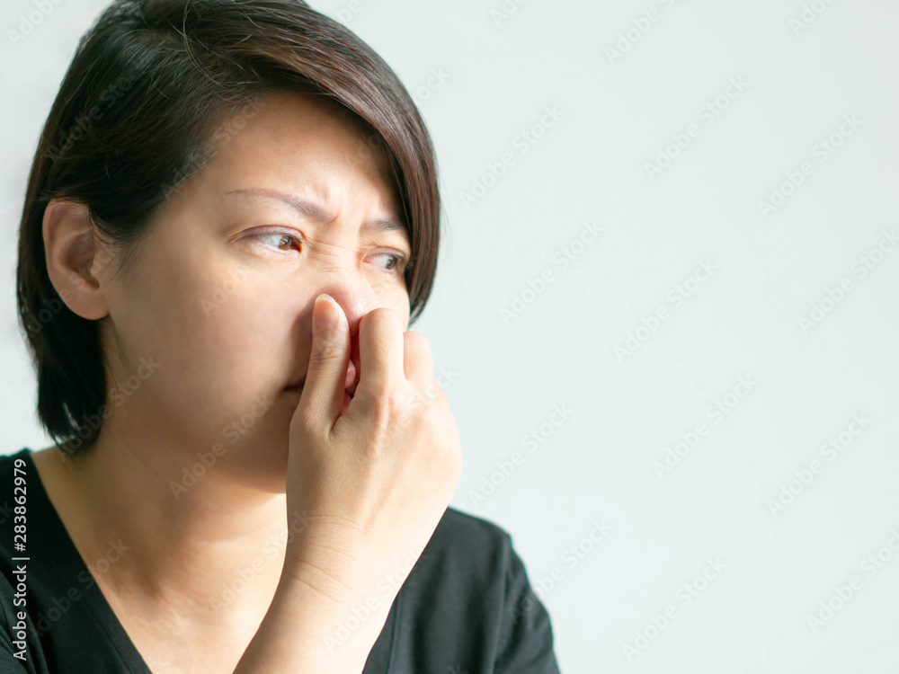 A caucasian woman use thumb and forefinger pinch her nose when scent bad smell. A caucasian woman use thumb and forefinger pinch her nose when scent bad smell.