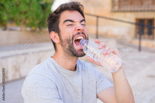 Young man driking water in the street