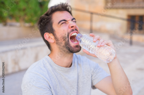 Young man driking water in the street