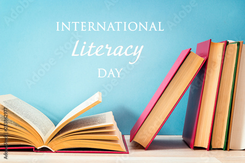 Quadro su tela International Literacy Day concept with stack of books on a blue background