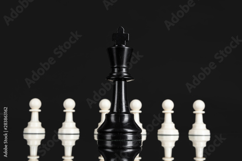 Chess figures on dark black background close up