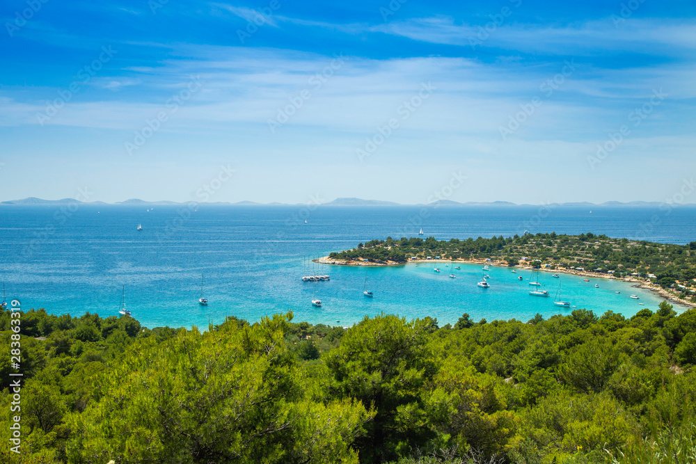 Croatia, Adriatic coast, panoramic view on Kosirina beach lagoon on Murter island, anchored sailing boats and yachts on blue sea