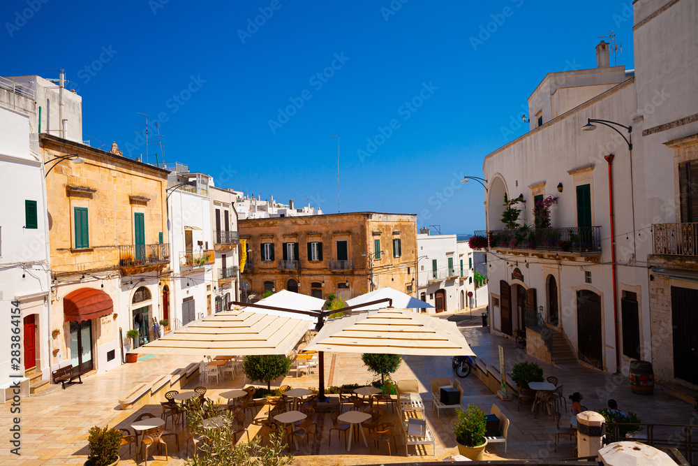 Ostuni, Italy - 12.08.19: old town with restaurants Ostuni is known as the white town.