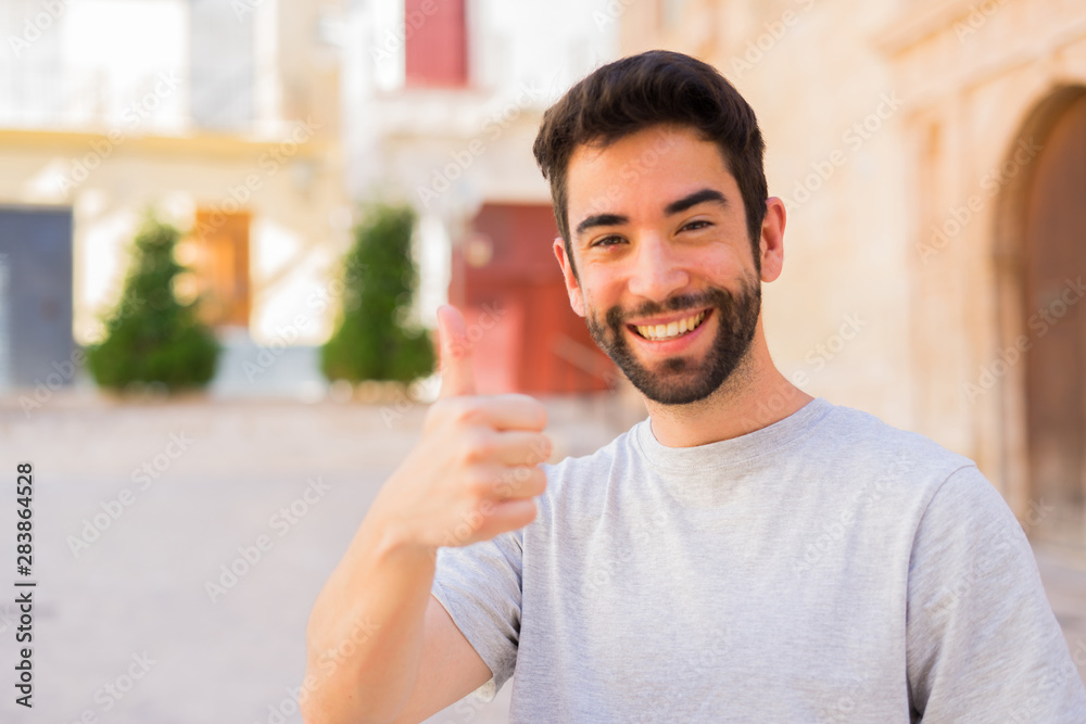 Young man thumb up in the street Young man thumb up in the street