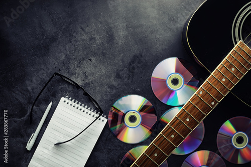Guitar and accessories on a stone background. Desk musician, headphones, microphone. photo