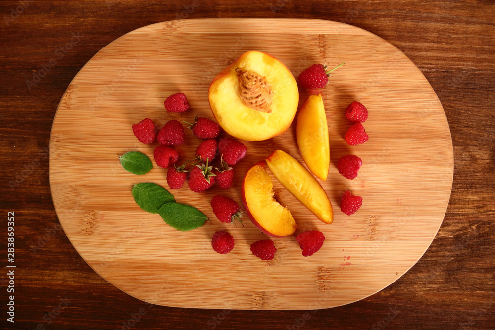 Raspberry and Peach Slices on cutting board Raspberry and Peach Slices on cutting board