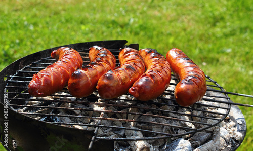 фотографія Grilling Sausages on barbecue grill