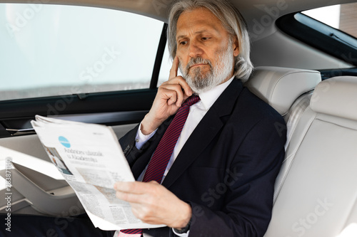 Senior businessman is driving to work in his car