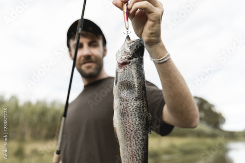 Person fishing a fish with a rod