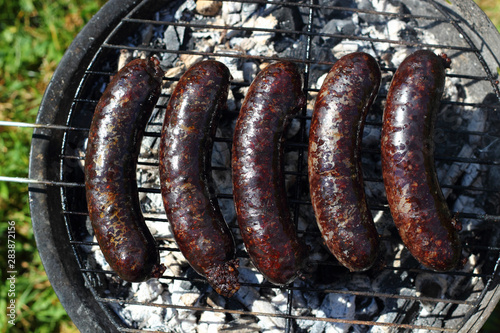 Grilling Blood Sausages on barbecue grill