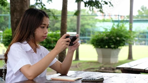 Woman playing video game on cell phone on the desk, technology outdoor concept