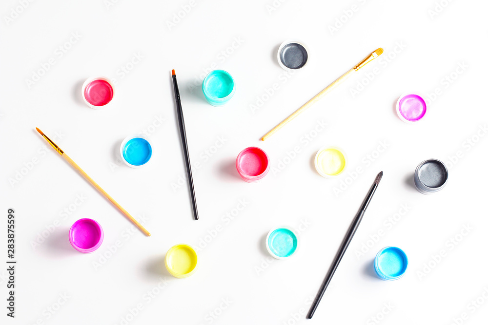 pattern of acrylic paint in cans and brushes. top view, flat lay