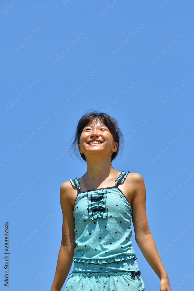 青空で笑う女の子（海水浴、水着）