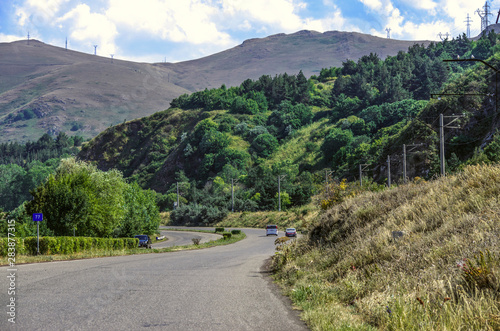 Road through the mountains among the trees leading to the high-mountain lake Sevan in Gegharkunik region of Armenia