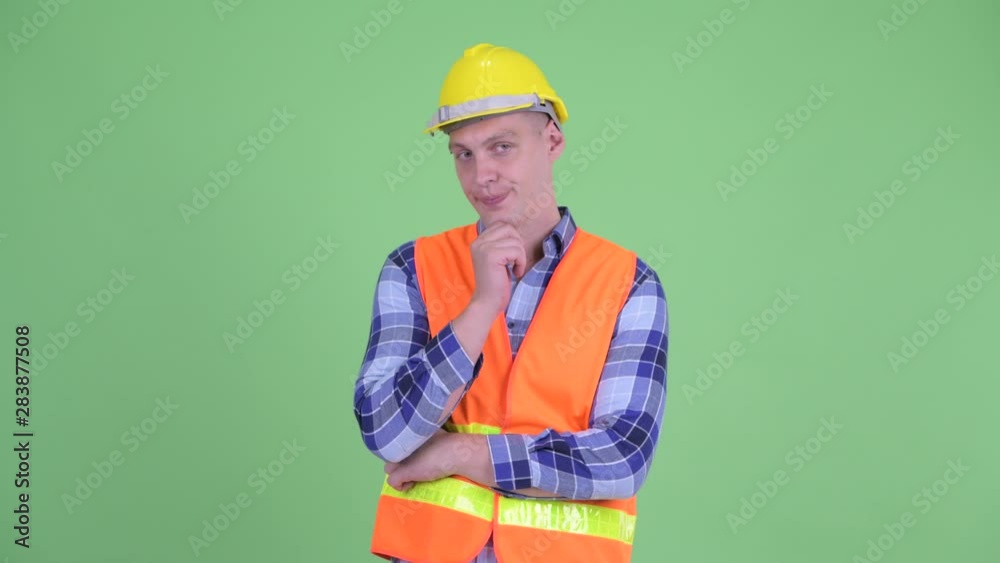 Stressed young man construction worker thinking and looking down Stressed young man construction worker thinking and looking down