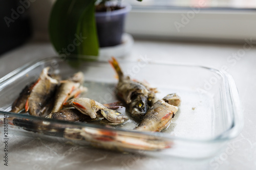 Backed fishes lying in glass plate on the kitchen. Healthy food concept