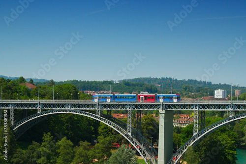 A tram runs over the bridge 'Kirchenfeldbrucke' in Bern, Switzerland on a summerday in 2019