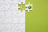 Separation of coin and bank note on puzzle on green background