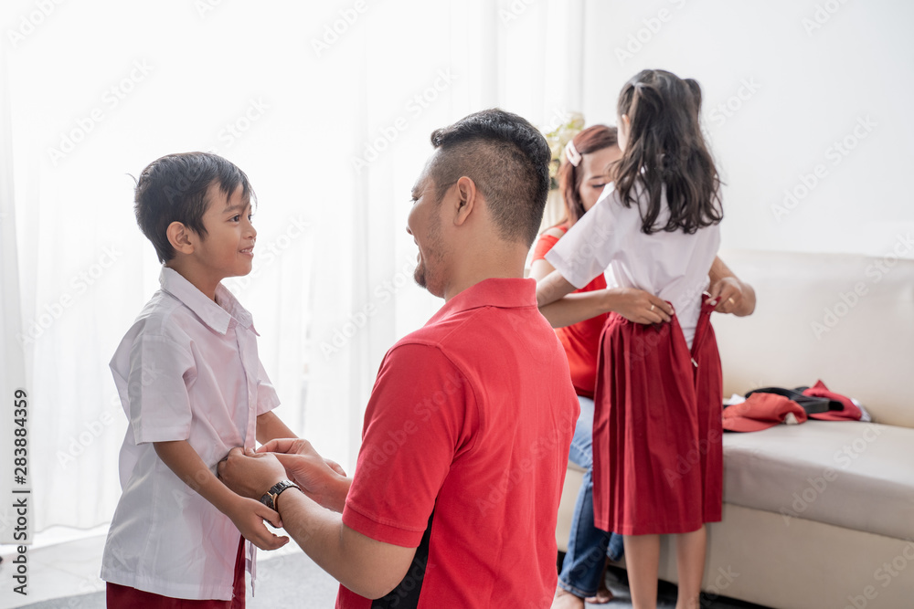 Obraz premium father help her son getting ready for school in the morning at home