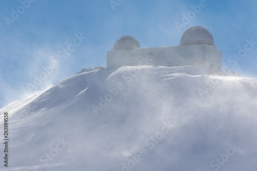 A mountain station with domes in the Spanish winter sports area Pradollano high in the Sierra Nevada. The strong wind causes considerable snowdrifts in the air.