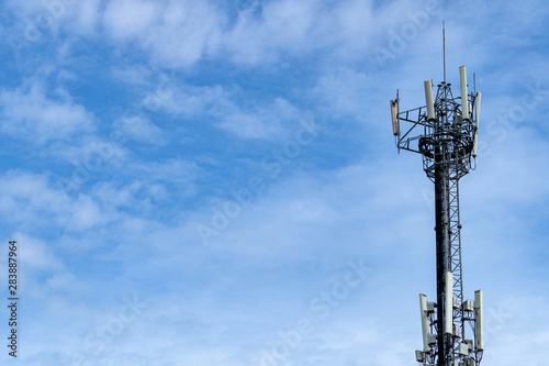 Telecommunication tower with blue sky and white clouds background. Antenna on blue sky. Radio and satellite pole. Communication technology. Telecommunication industry. Mobile or telecom 4g network.