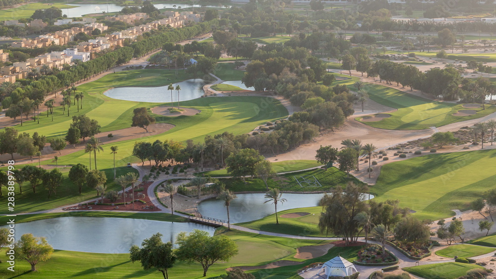 Aerial view to villas and houses with Golf course with green lawn and lakes timelapse