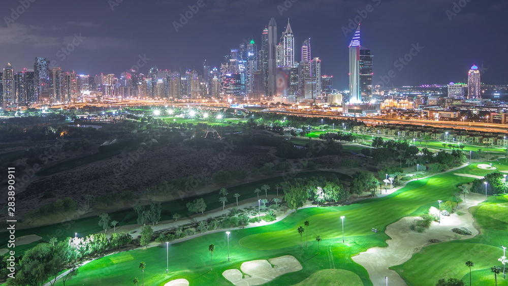 Fototapeta premium Wieżowce Dubai Marina i timelapse noc na polu golfowym, Dubaj, Zjednoczone Emiraty Arabskie