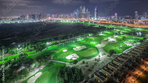 Dubai Marina skyscrapers and golf course night timelapse, Dubai, United Arab Emirates photo