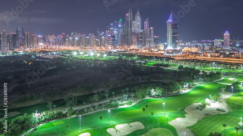 Dubai Marina skyscrapers and golf course night timelapse, Dubai, United Arab Emirates photo