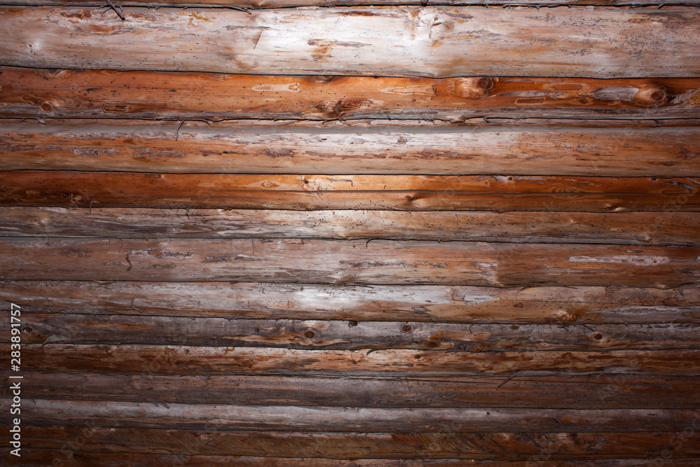 Naklejka premium lit ceiling made of round logs, view from below