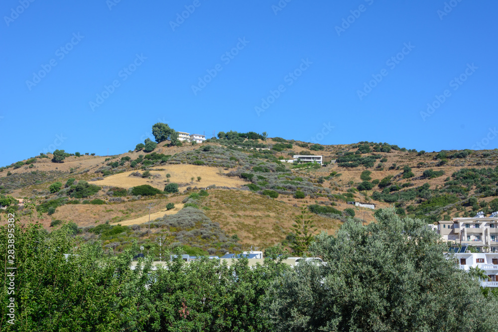 mountain view with single Mediterranean houses, trees and gardens