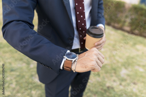Close-up lawyer with coffee looking at his watch