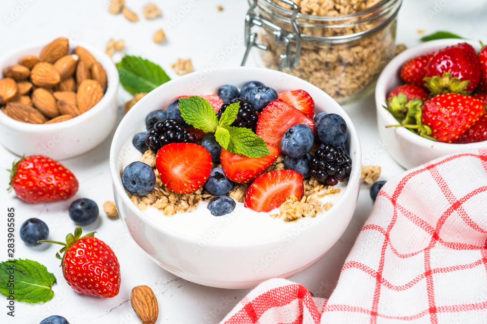 Greek yogurt granola with fresh berries on white table. Greek yogurt granola with fresh berries on white table.