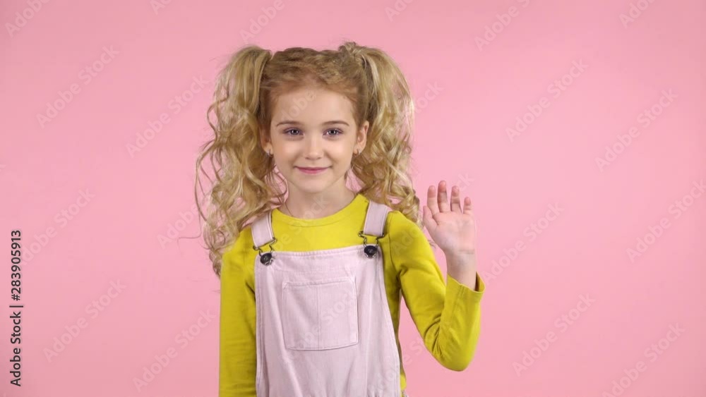 Young girl is waving hello with her hand. Slow motion Young girl is waving hello with her hand. Slow motion