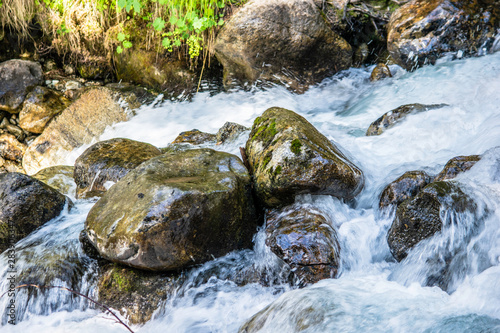 the water of the stormy mountain river flowing among stones and boulders