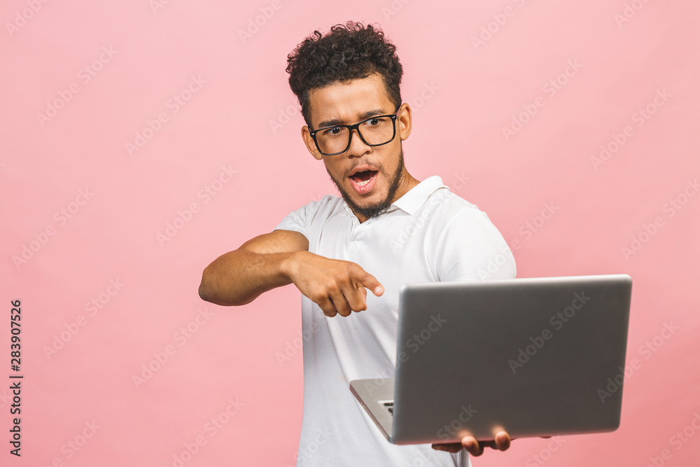 Afro american young man using laptop over isolated pink background surprised with an idea or question pointing finger with happy face, number one. Afro american young man using laptop over isolated pink background surprised with an idea or question pointing finger with happy face, number one.