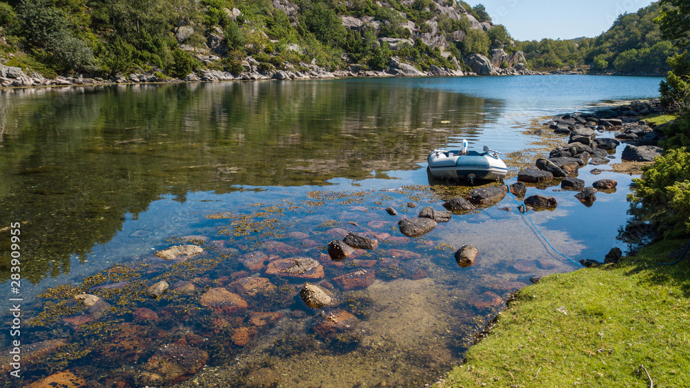 Zodiac dinghy in an idyllic and lush anchorage Zodiac dinghy in an idyllic and lush anchorage