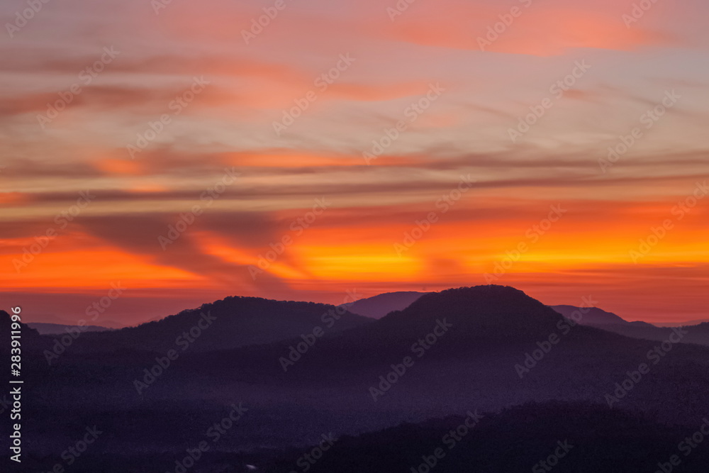 Mountain view morning of Peak mountain above Mekong river around with soft mist and red sun light in the sky background, sunrise at Cha Na Dai Cliff, Pha Taem National Park, Ubon Ratchathani, Thailand Mountain view morning of Peak mountain above Mekong river around with soft mist and red sun light in the sky background, sunrise at Cha Na Dai Cliff, Pha Taem National Park, Ubon Ratchathani, Thailand