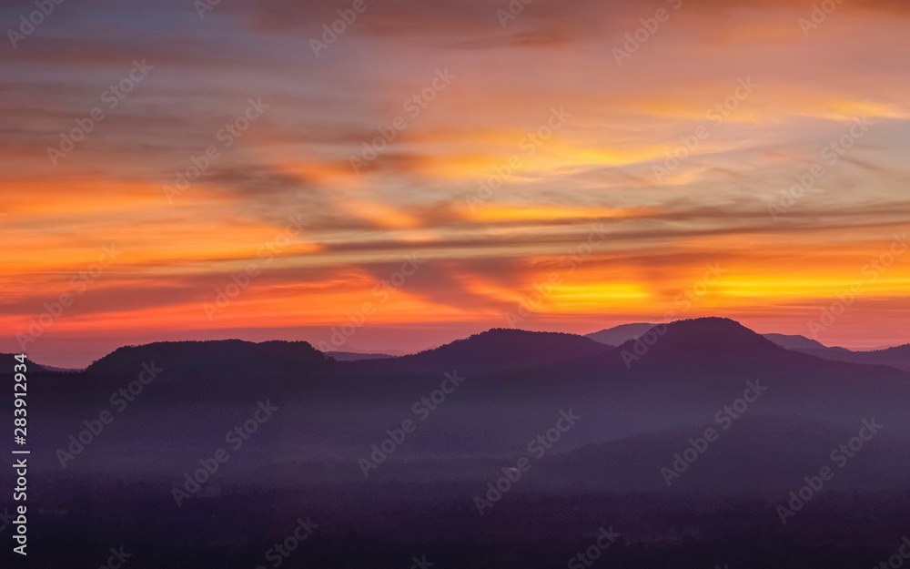 Mountain view morning of Peak mountain above Mekong river around with soft mist and red sun light in the sky background, sunrise at Cha Na Dai Cliff, Pha Taem National Park, Ubon Ratchathani, Thailand Mountain view morning of Peak mountain above Mekong river around with soft mist and red sun light in the sky background, sunrise at Cha Na Dai Cliff, Pha Taem National Park, Ubon Ratchathani, Thailand