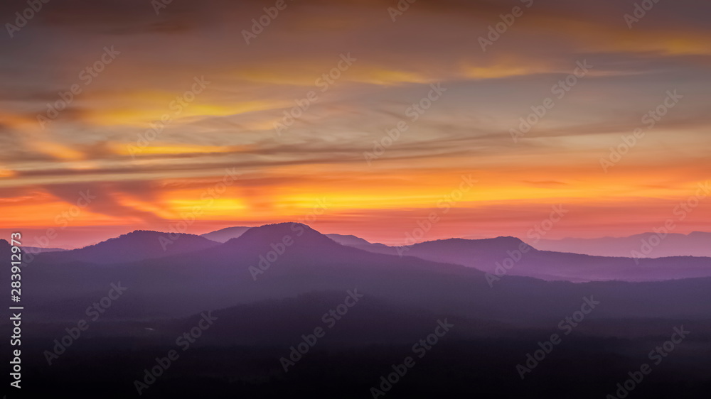 Mountain view morning of Peak mountain above Mekong river around with soft mist and red sun light in the sky background, sunrise at Cha Na Dai Cliff, Pha Taem National Park, Ubon Ratchathani, Thailand Mountain view morning of Peak mountain above Mekong river around with soft mist and red sun light in the sky background, sunrise at Cha Na Dai Cliff, Pha Taem National Park, Ubon Ratchathani, Thailand