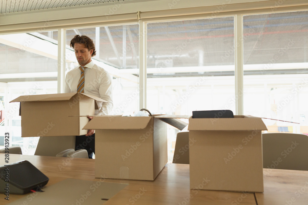 Businessman holding a cardboard box in the conference room Businessman holding a cardboard box in the conference room