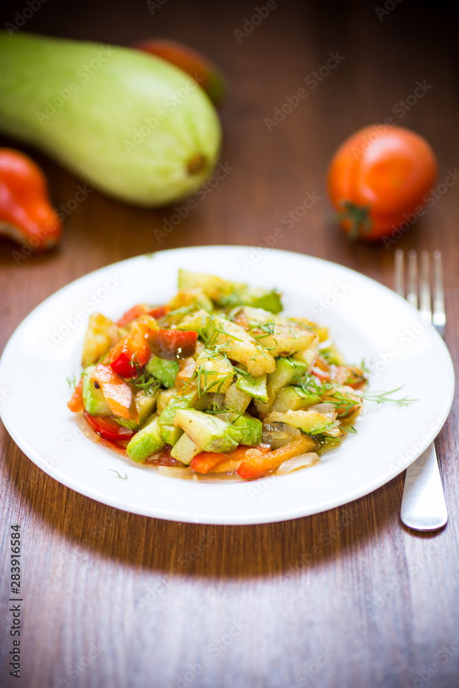 fried zucchini with red pepper, onions, tomatoes and other vegetables fried zucchini with red pepper, onions, tomatoes and other vegetables