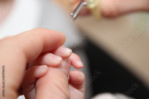 Nägel schneiden bei einem Neugeborenem