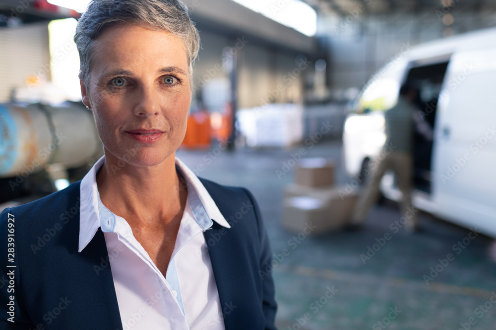 Happy female manager looking at camera in warehouse Happy female manager looking at camera in warehouse